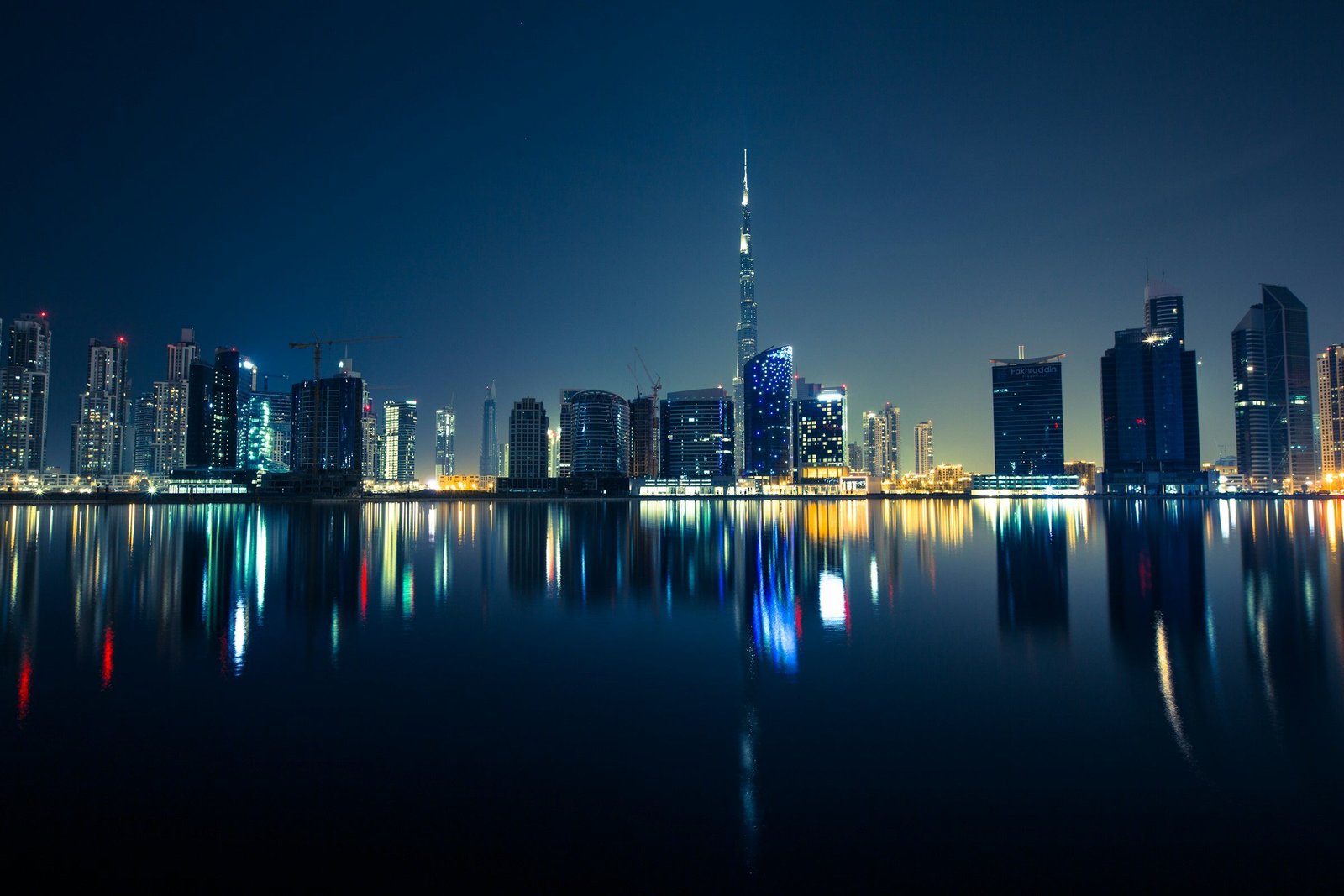 Dubai skyline at night with the Burj Khalifa reflected in the water